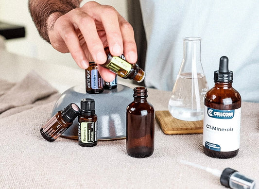 Man pouring tea tree essential oil into amber spray bottle for Hair Growth Spray recipe