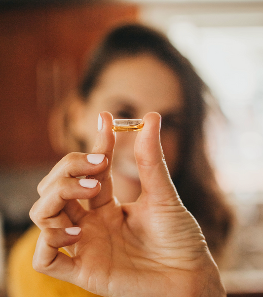 woman holding up supplement capsule